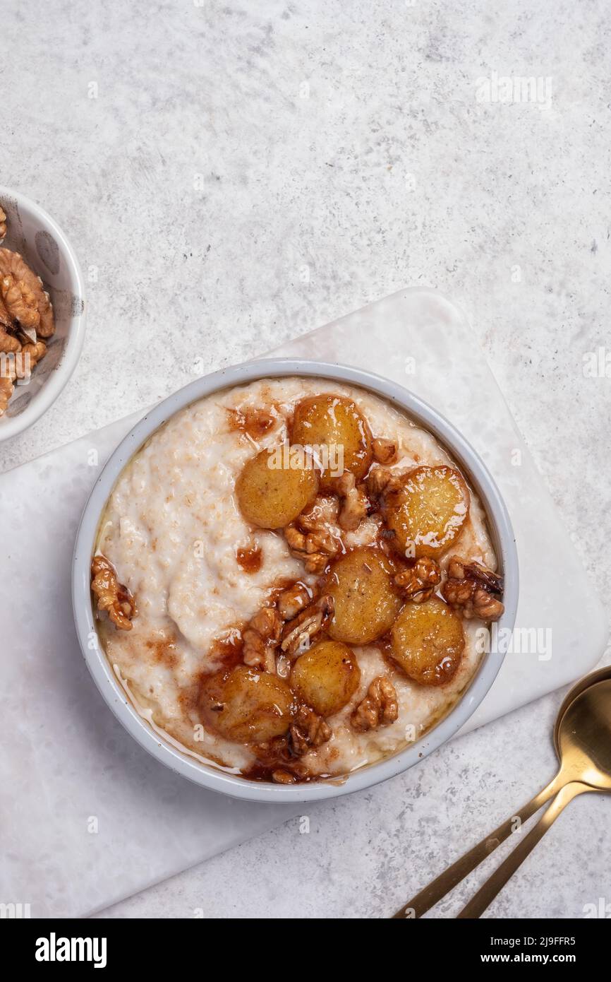 Porridge with caramelised banana and walnut for healthy breakfast Stock Photo