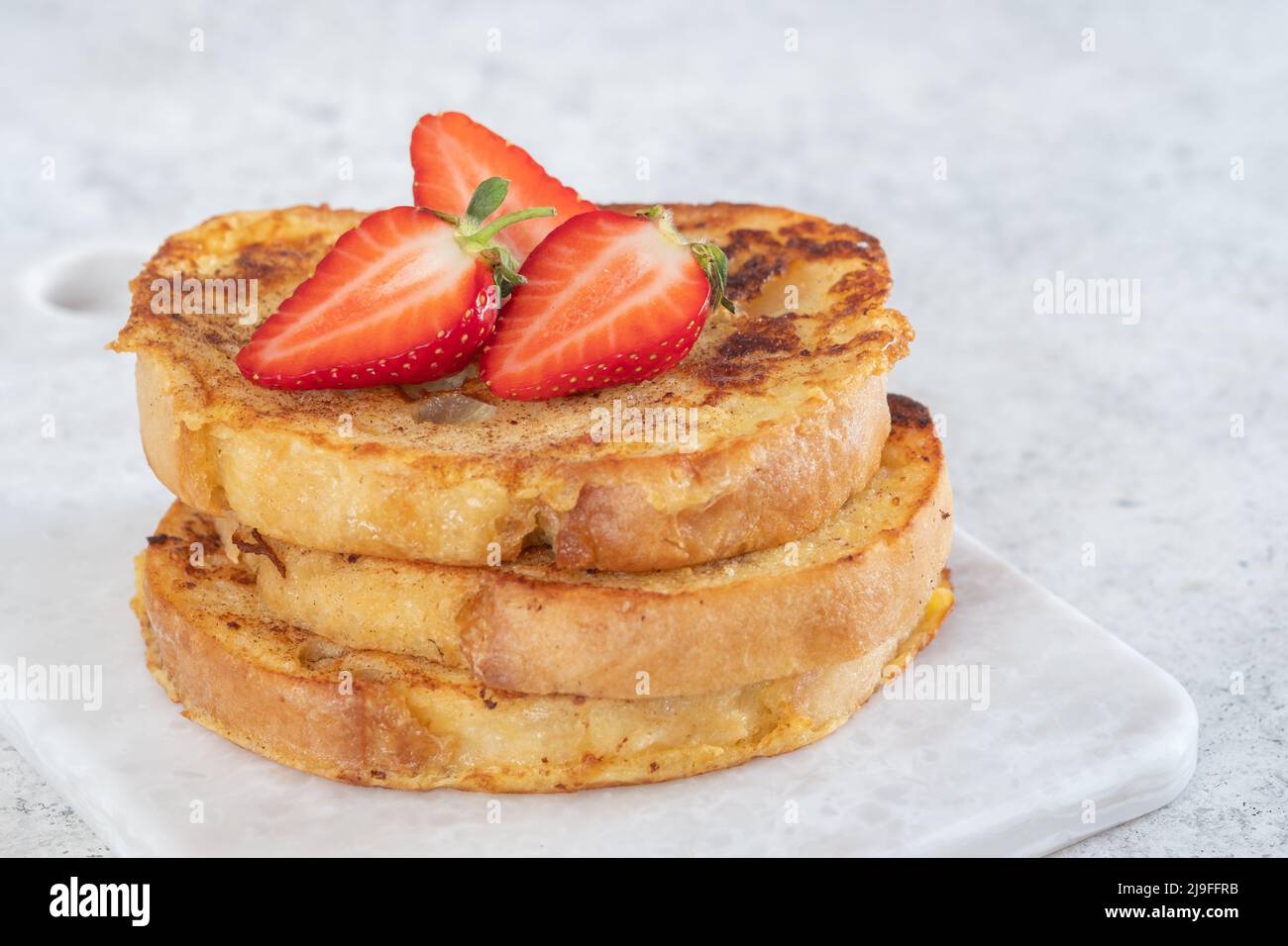 French toast with strawberries, maple syrup and sugar for breakfast Stock Photo