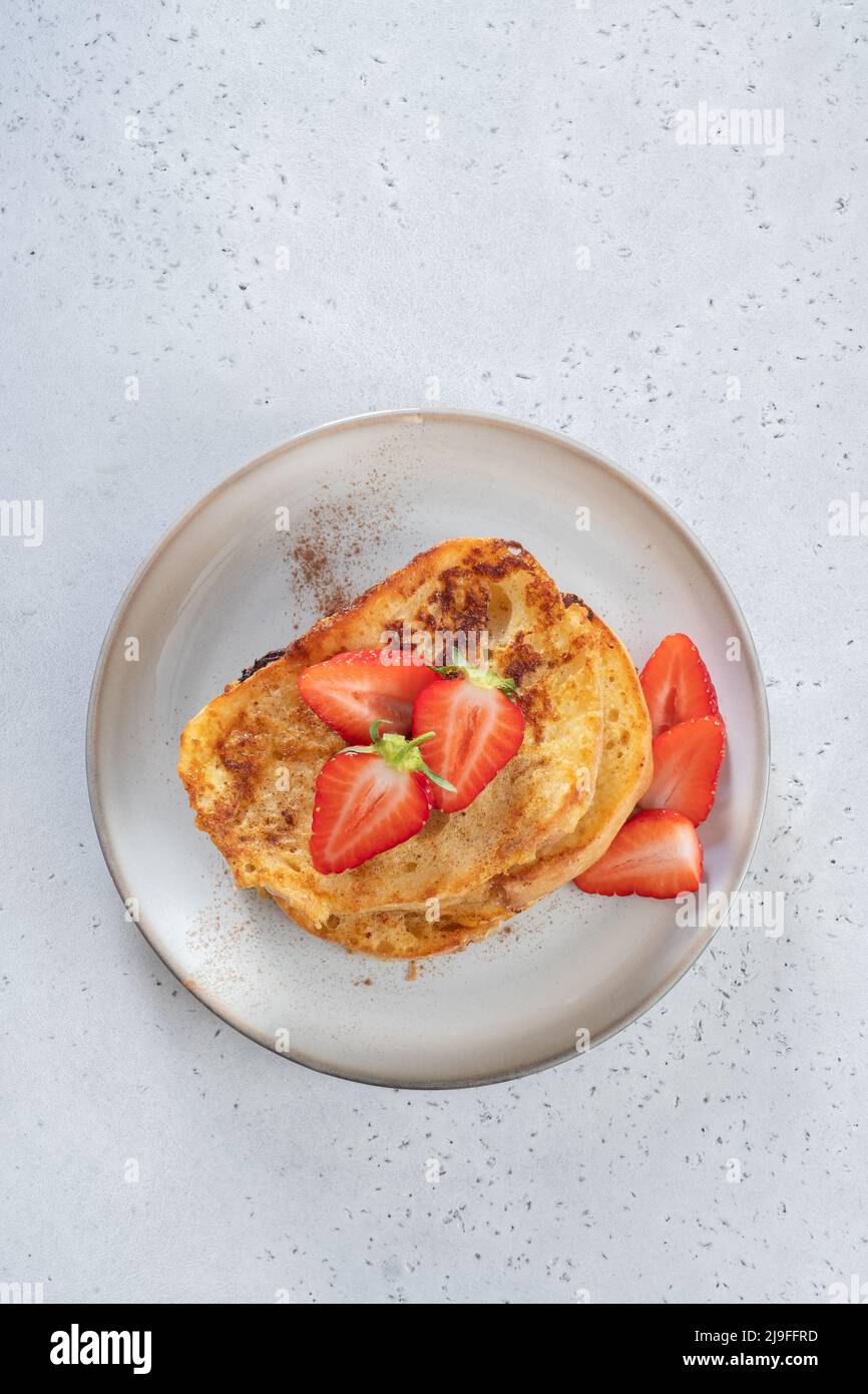 French toast with strawberries, maple syrup and sugar for breakfast Stock Photo