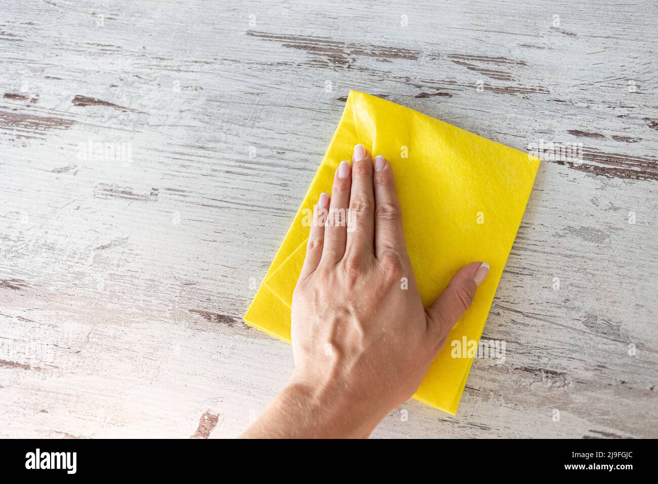 Cleaning yellow napkin in the hands of a woman. cleaning service. The ...
