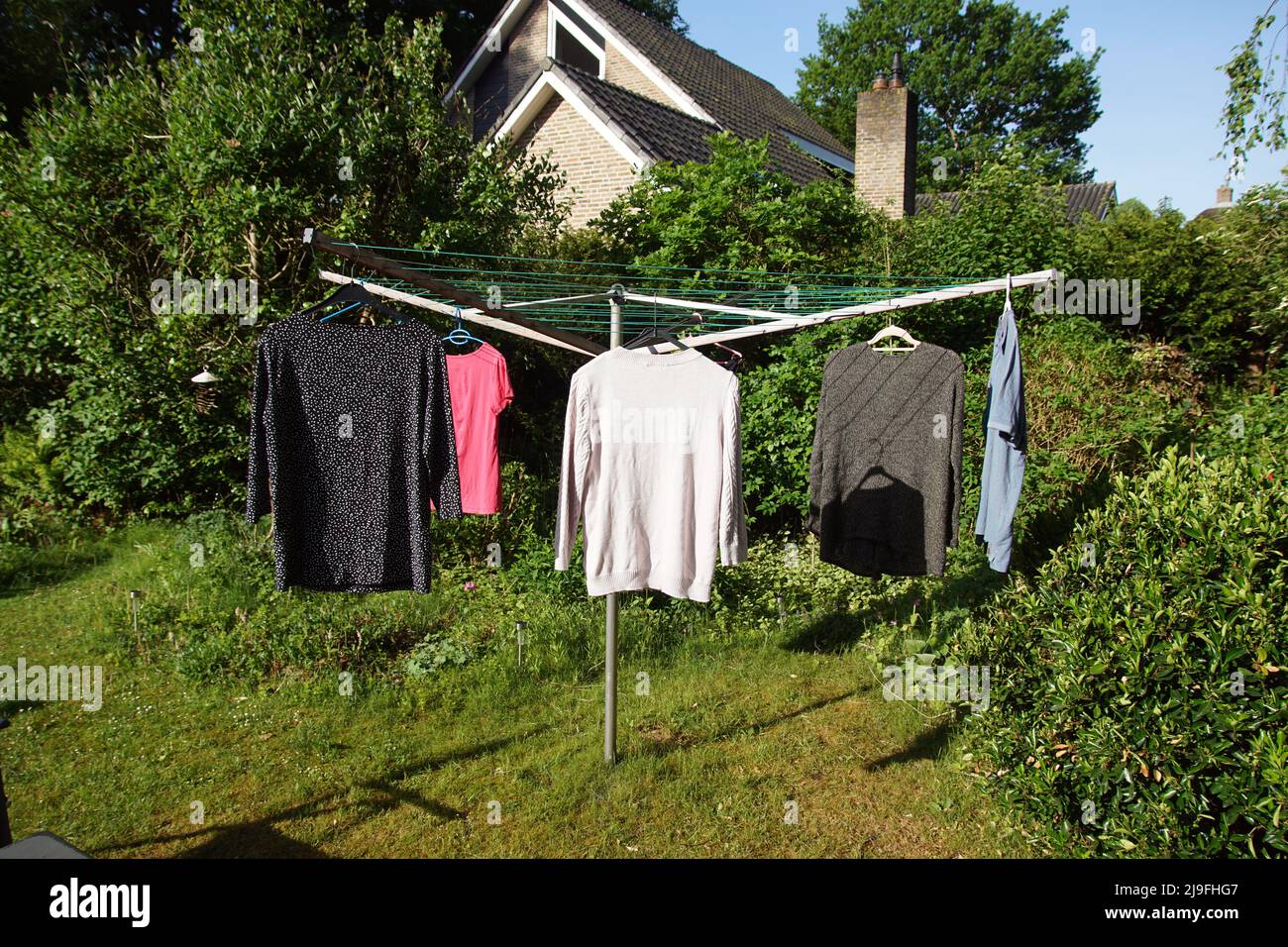 The laundry hanging on the line of a rotary umbrella clothesline in the sun in a Dutch garden. Spring May Stock Photo Alamy