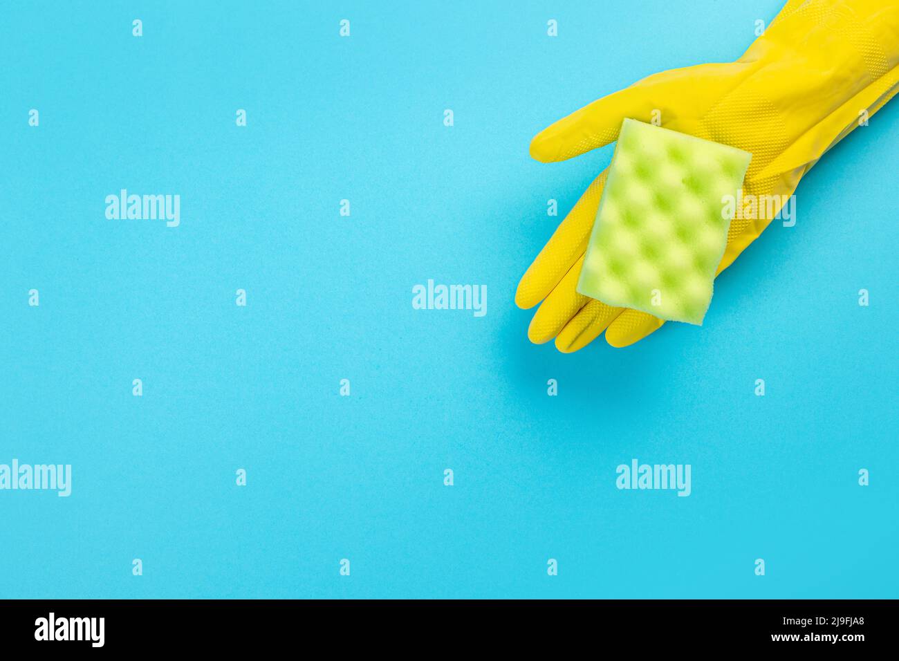 worker's hand in yellow rubber protective glove with micro fiber green ...