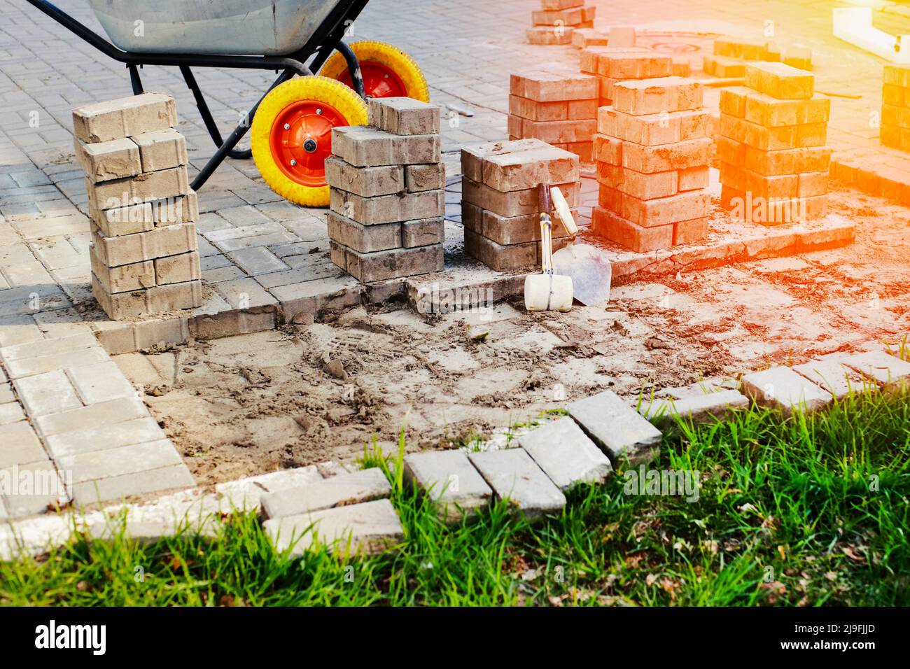 View of new paving slabs and concrete blocks on summer day at construction site. Stone blocks stand in stack. Repair of square and sidewalks. Restoration of road surface. Stock Photo