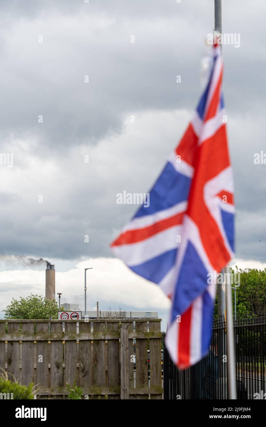 A union jack flag flies in front of the chimney stack of a biomass power station, Lynemouth, Northumberland, UK. Stock Photo