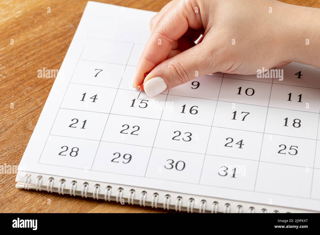 red Hand pin stuck on the day of the month in the calendar business red Hand pin stuck on the day of the month in the calendar business