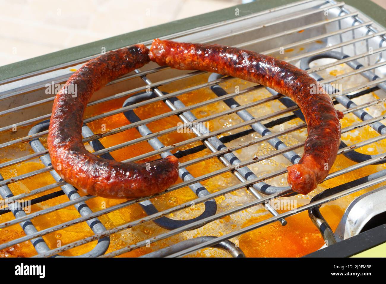 Merguez on the grid of an electric barbecue Stock Photo
