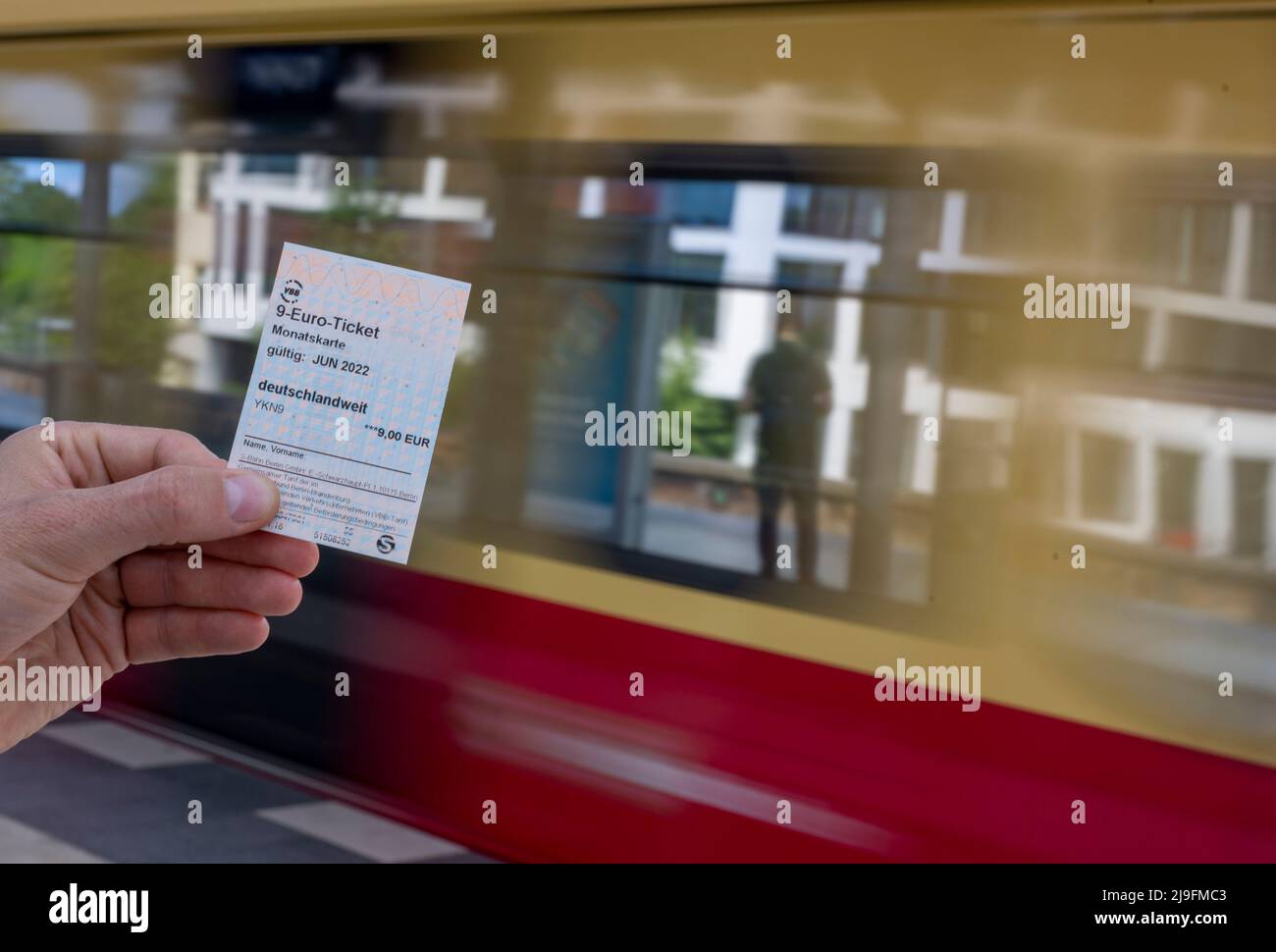 Berlin, Germany. 23rd May, 2022. A 9-euro ticket can be seen against the  background of an arriving S-Bahn (posed photo). Deutsche Bahn and numerous  transport associations are starting to sell the 9-euro