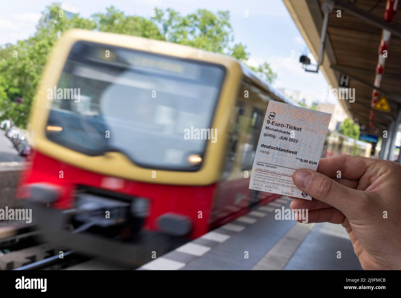 Berlin, Germany. 23rd May, 2022. A 9-euro ticket can be seen against the  background of an arriving S-Bahn (posed photo). Deutsche Bahn and numerous  transport associations are starting to sell the 9-euro