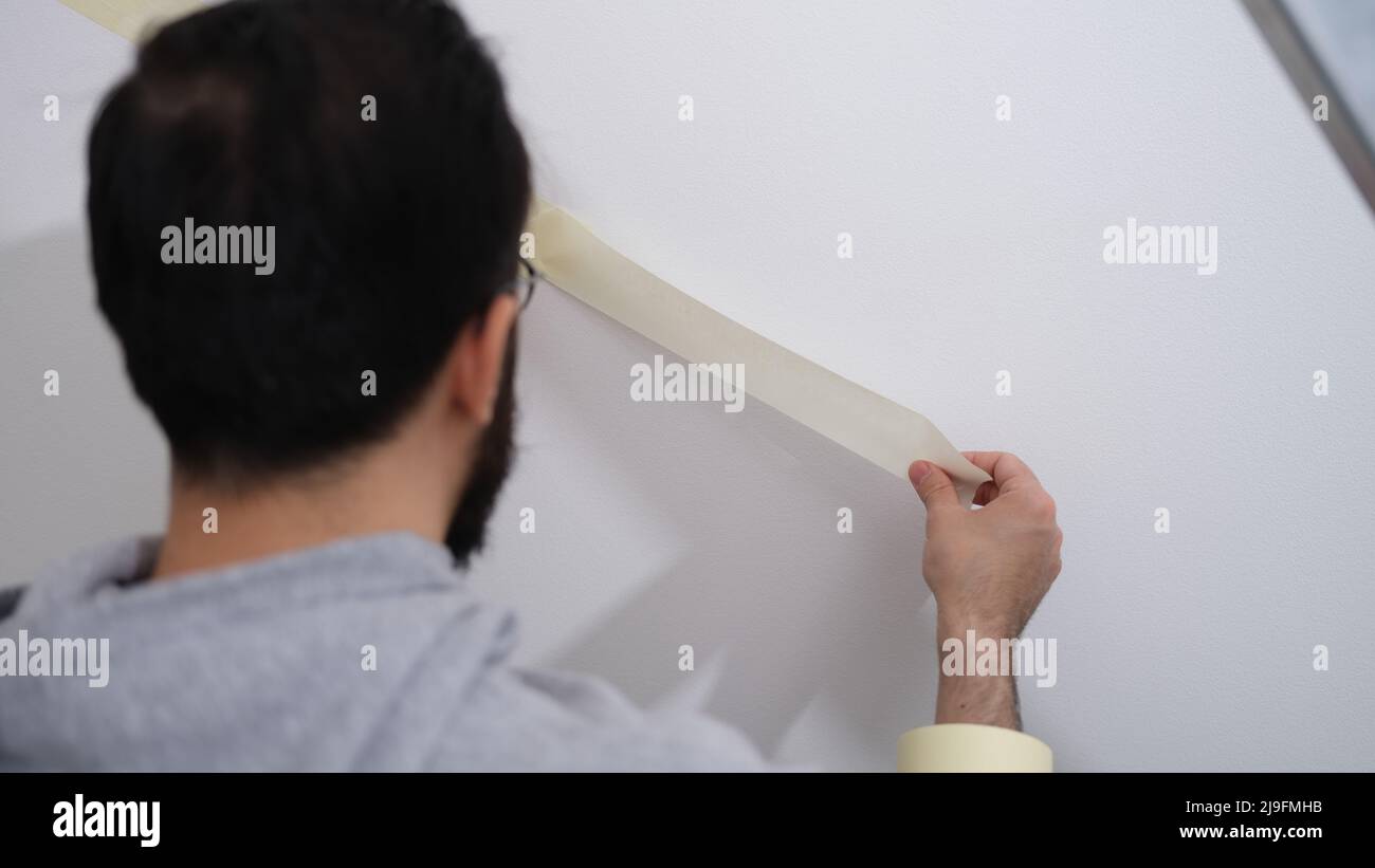 Home repair service master uses masking tape before painting Stock