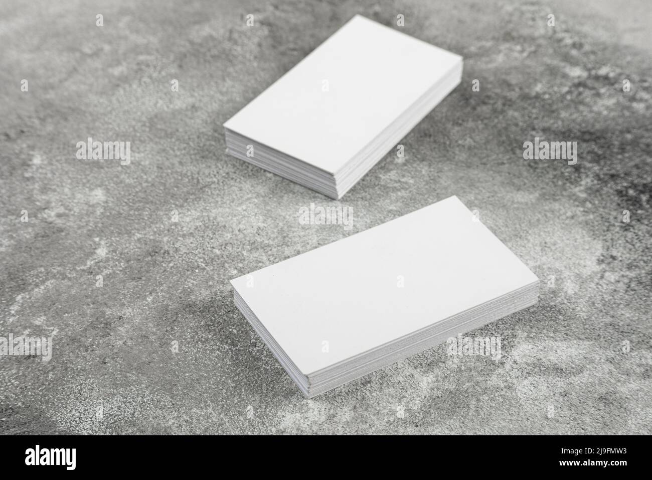 Photo of a stack of blank business cards on a stone table. Template for
