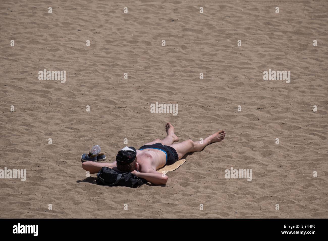 Barcelona, Spain. 22nd May, 2022. A man is seen sunbathing lying on the