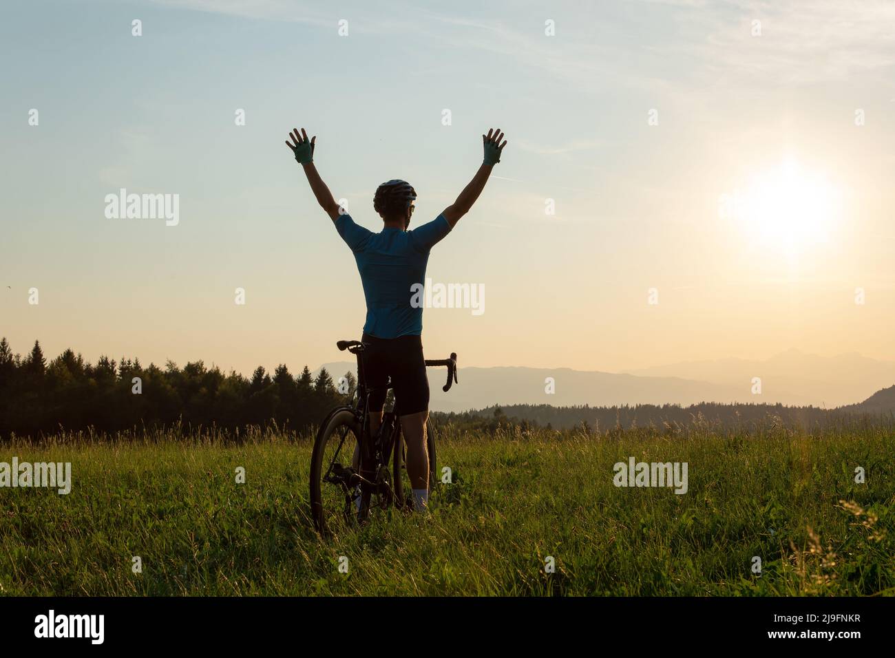 Male athlete professional racing cyclist riding a bike with arms raised