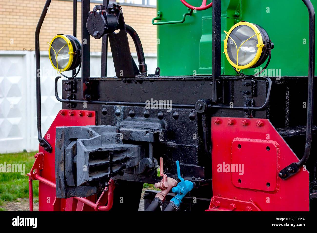 Two electric headlights on a retro train front on the rail platform