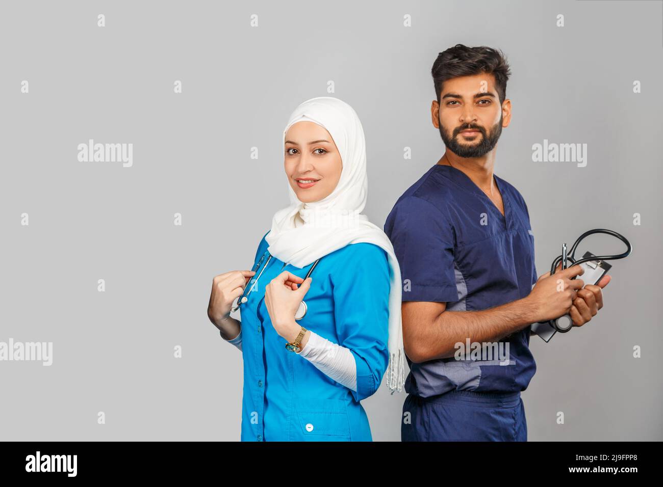 professional muslim doctor woman and indian assistant discuss tasks ...