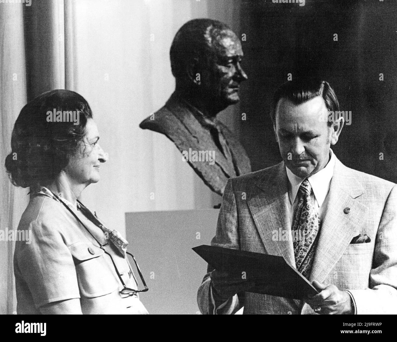 Dr. Christopher C. Kraft, Director of the Johnson Spacecraft Center in Houston, Texas, right, reads the Dedication Citation to former first lady Lady Bird Johnson, left, after the unveiling of the former United States President Lyndon B. Johnson bust during the Dedication Services naming the Spacecraft Center in the honor of the former President on August 27, 1973. Credit: NASA via CNP Stock Photo