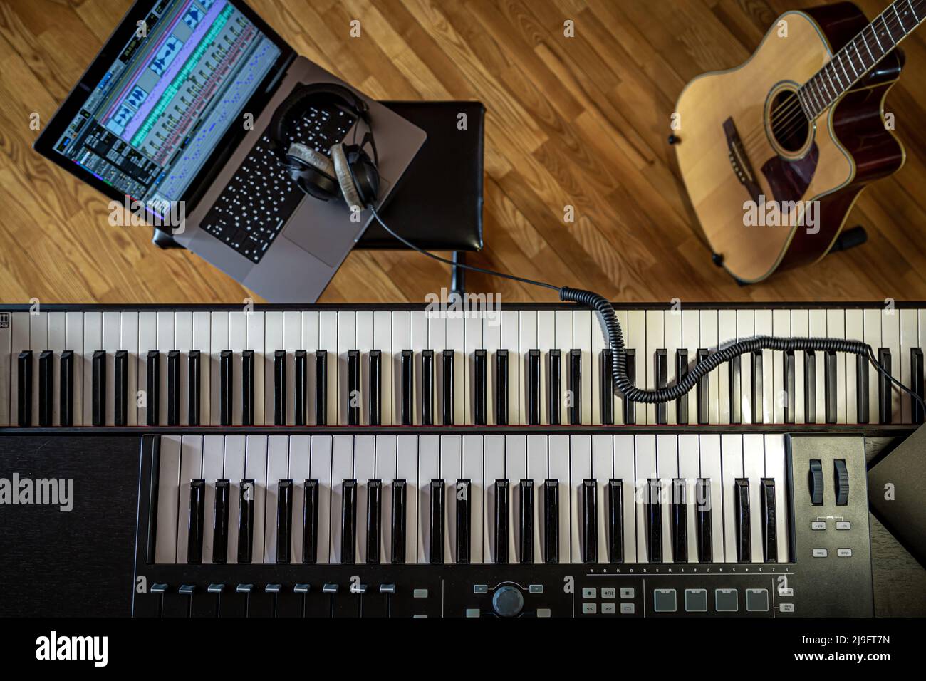 Piano keys, top view, musician's workplace with laptop. Stock Photo