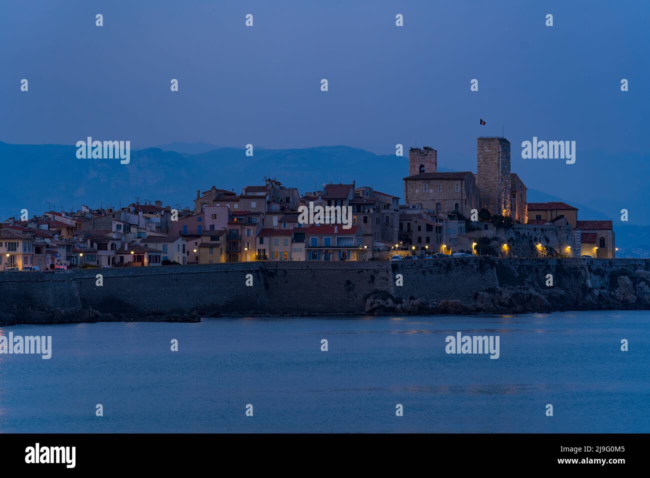 Landscape view on the old coastal village and fortification of Antibes on the french riviera in France during the blue hour Stock Photo