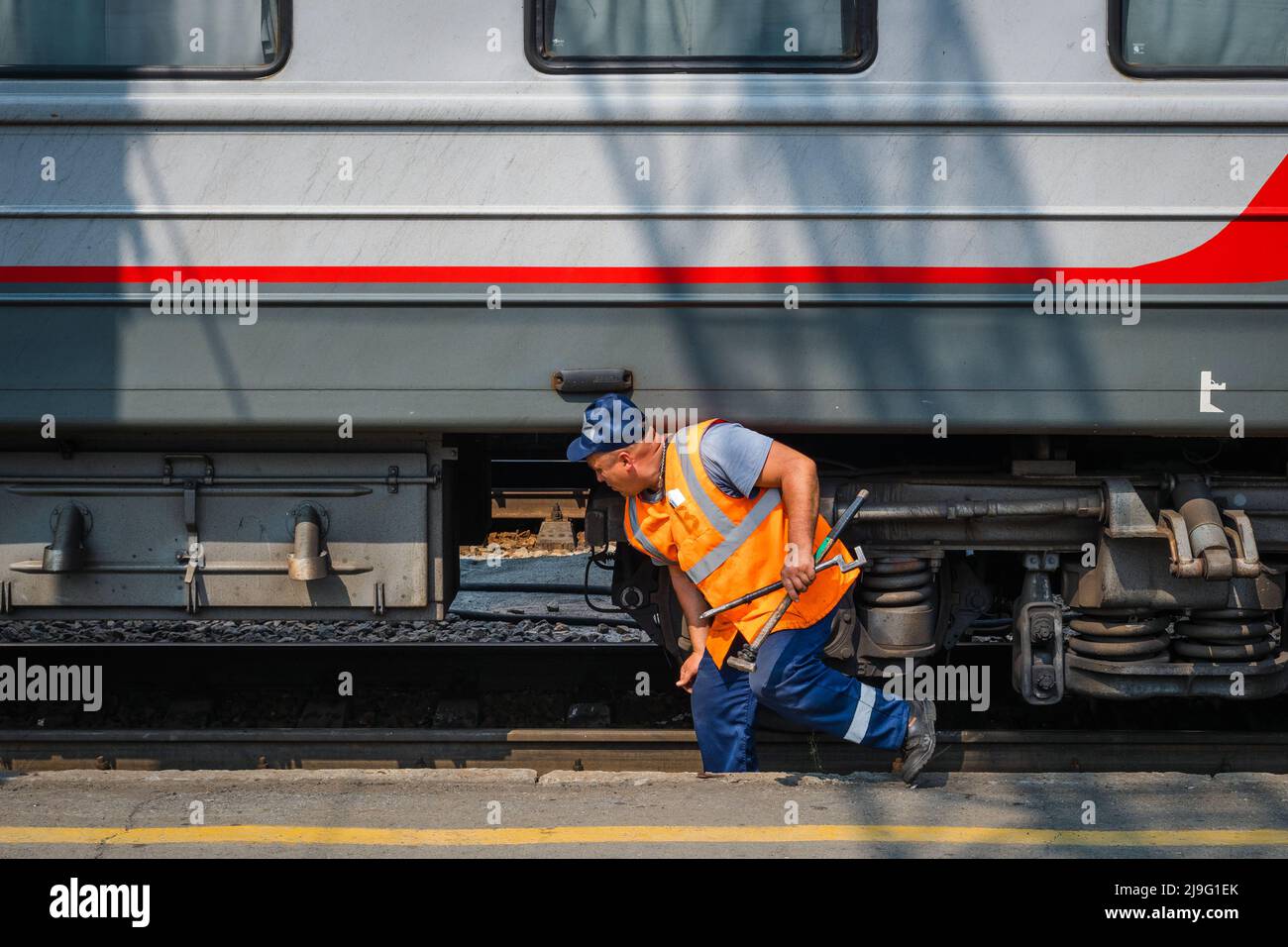 Train mechanic doing maintenance at the Novosibirsk-Glavny Railway Station in Novosibirsk, Russia, an important stop along the Trans-Siberian Railway. Stock Photo