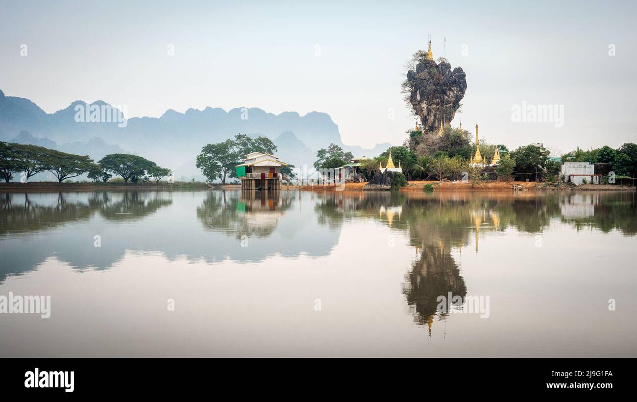 Kyaut Ka Latt Pagoda perched atop a rock cliff on a lake in Hpa-An, Myanmar (Burma). Stock Photo