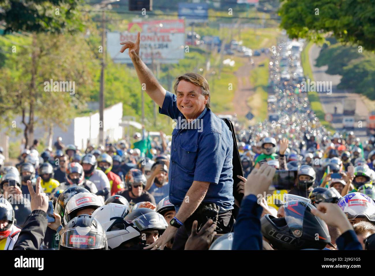 Maringa, Brazil. 11 May, 2022. Brazilian President Jair Bolsonaro, center, waves as he is carried by the crowds after arriving by motorcycle at the 48th Expoinga Agricultural fair at the Francisco Feio Ribeiro Expo Center, May 11, 2022 in Maringa, Brazil. Credit: Alan Santos/President Brazil/Alamy Live News Stock Photo