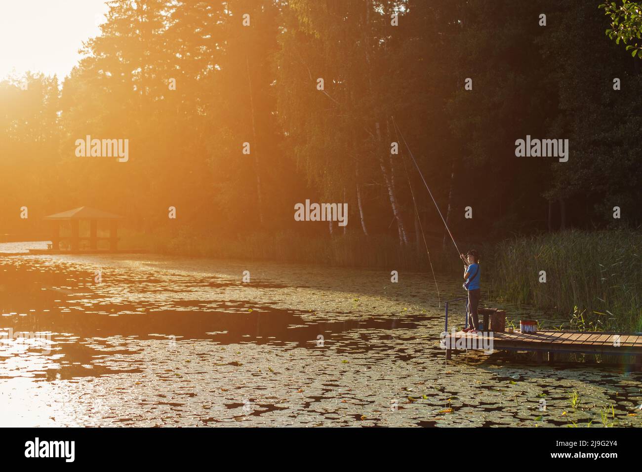 A small toddler boy standing by a lake at sunset, fishing. Copy space Stock  Photo - Alamy