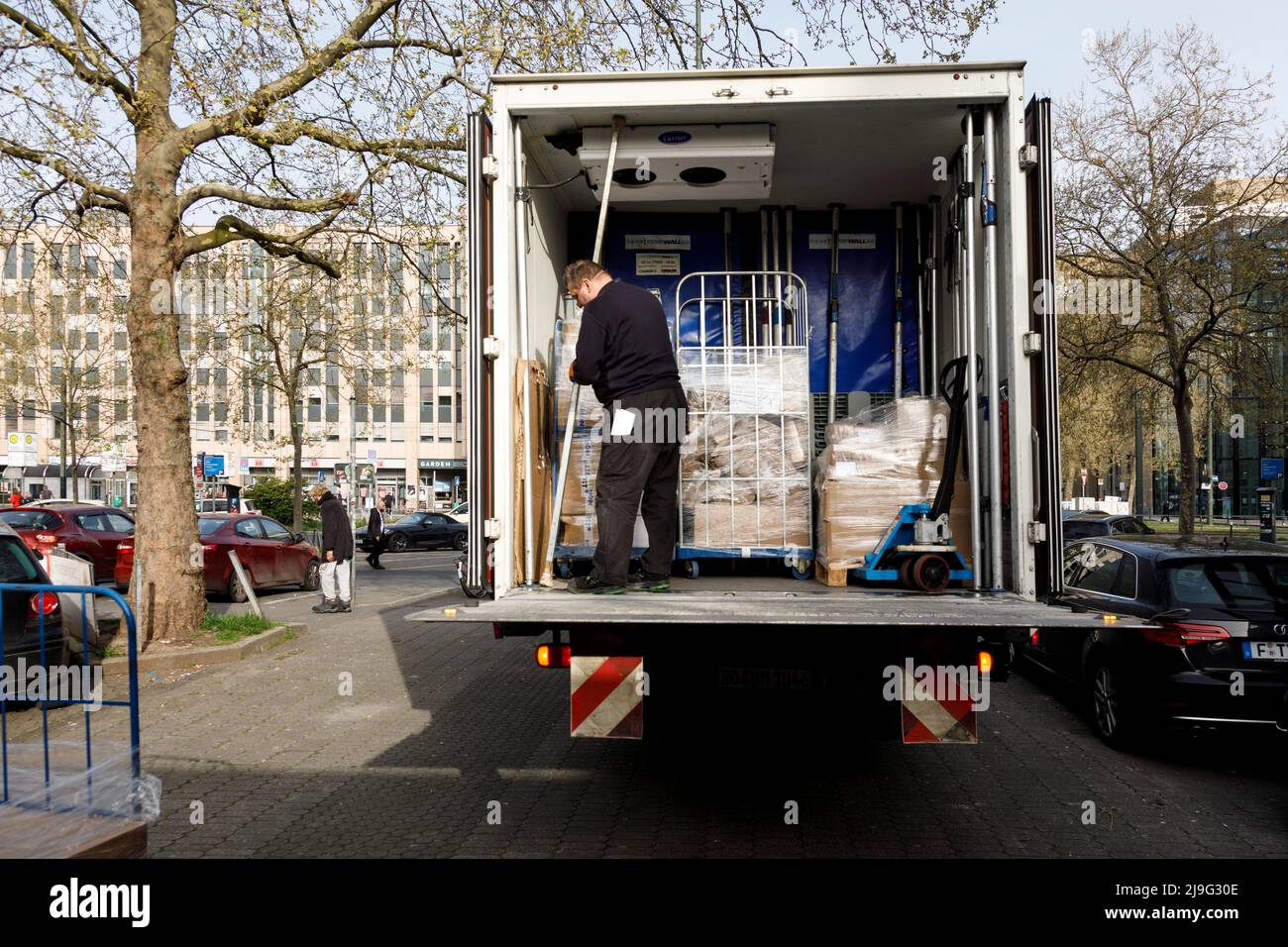 Delivery traffic, delivery of deep-frozen goods at Düsseldorf main station, driver securing the load Stock Photo