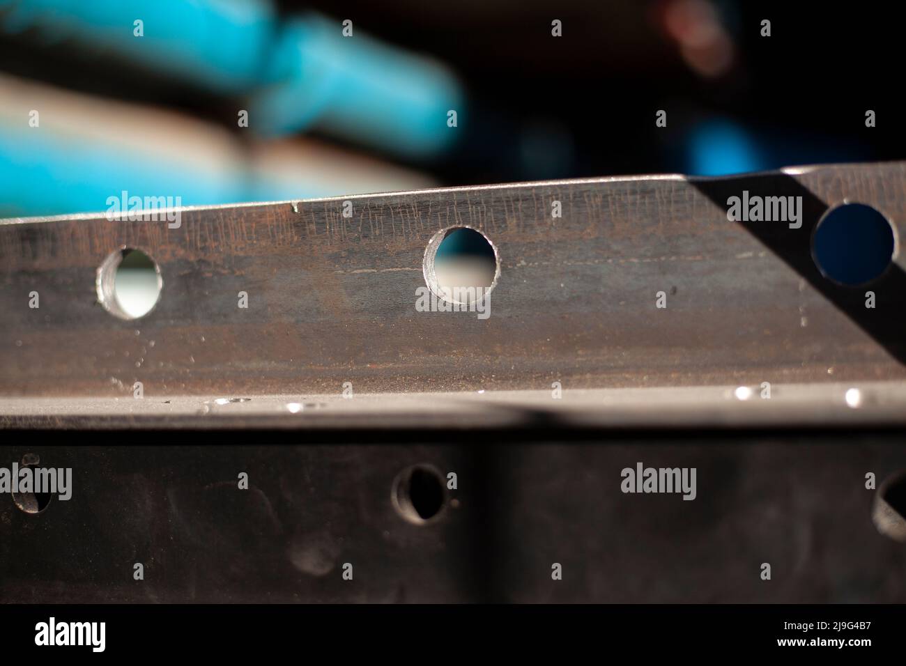 Holes in steel from drilling. Metal blank. Steel profile is drilled