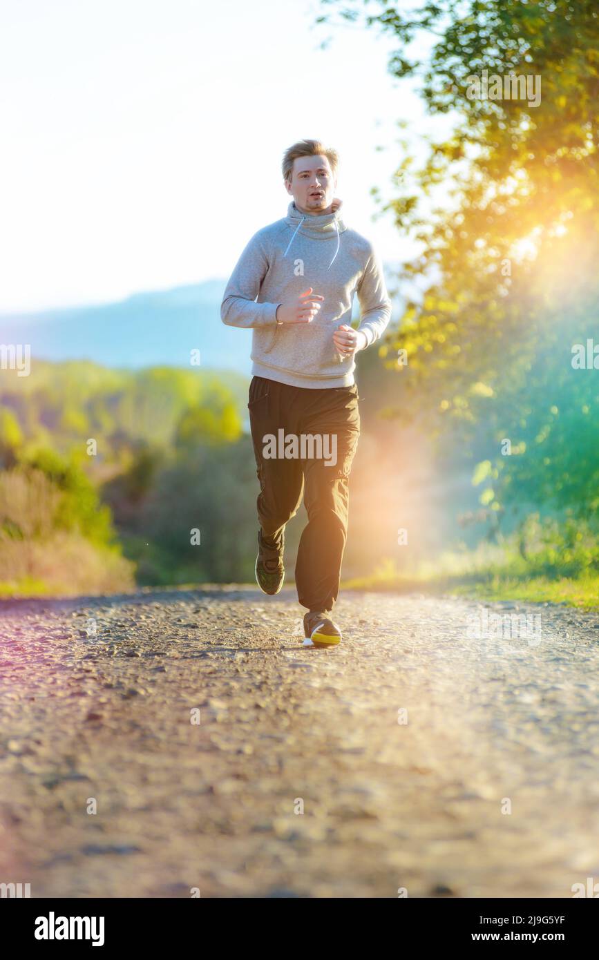 Jogging Portrait Running man jogging in rural nature at beautiful summer day. Sport ...