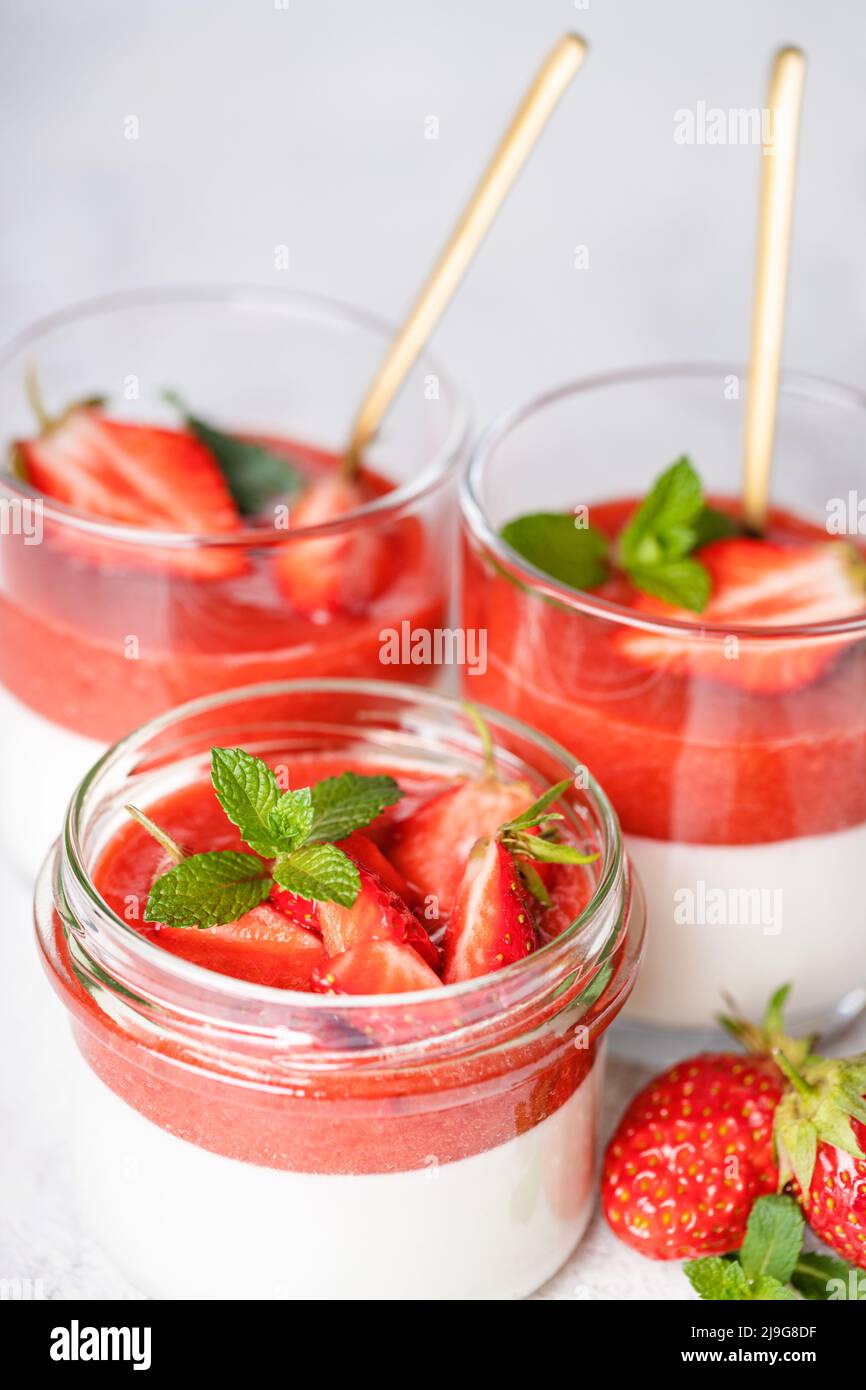 Panna cotta in glass jars with strawberry sauce. Stock Photo