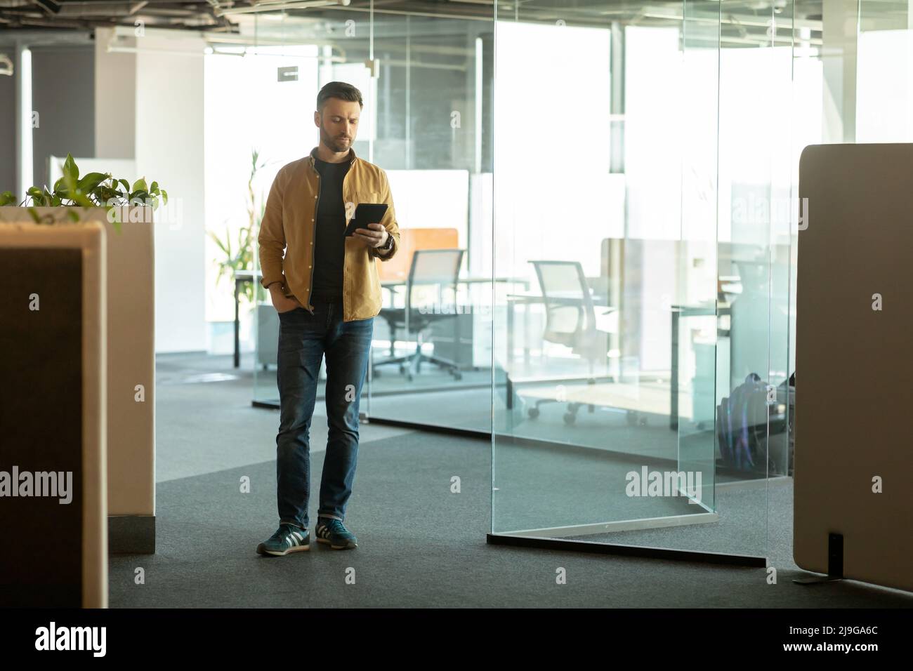 Cheerful Businessman Using Digital Tablet Computer Entering Modern Office Stock Photo