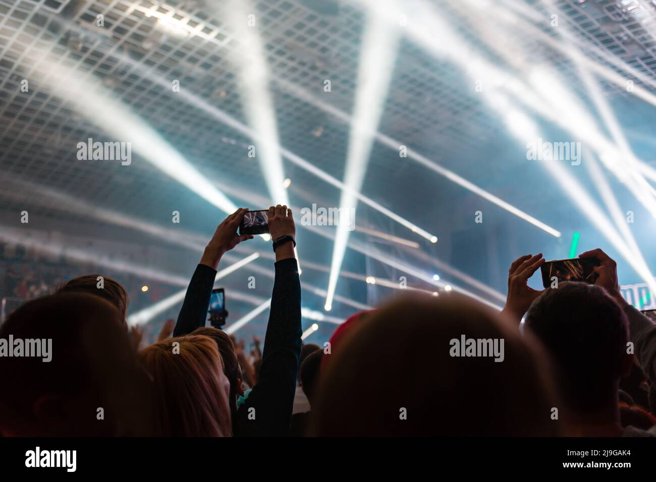 A crowd of people at the concert have fun and dance to the music at the