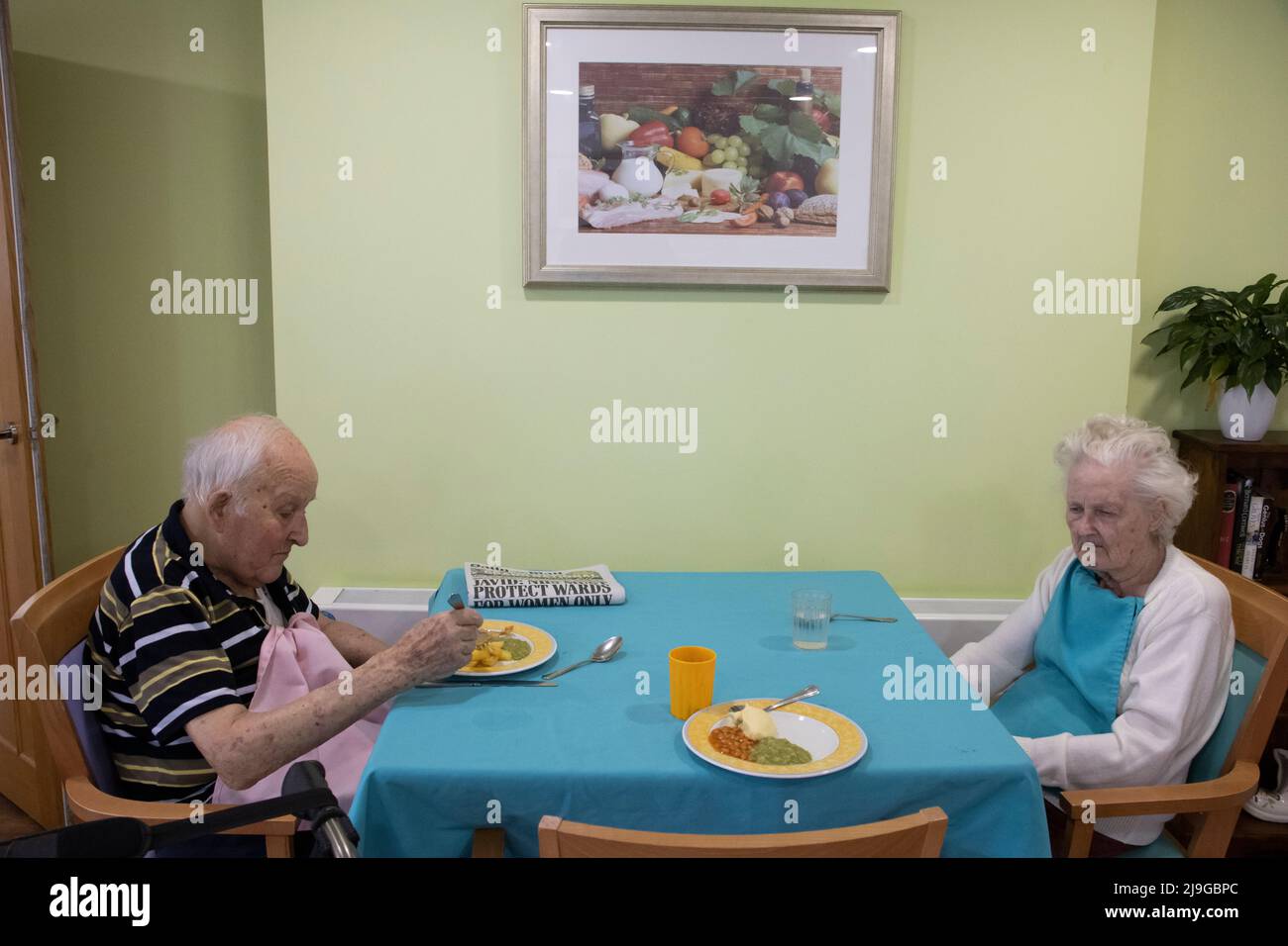 Elderly couple sat at a dining table in a residential care home