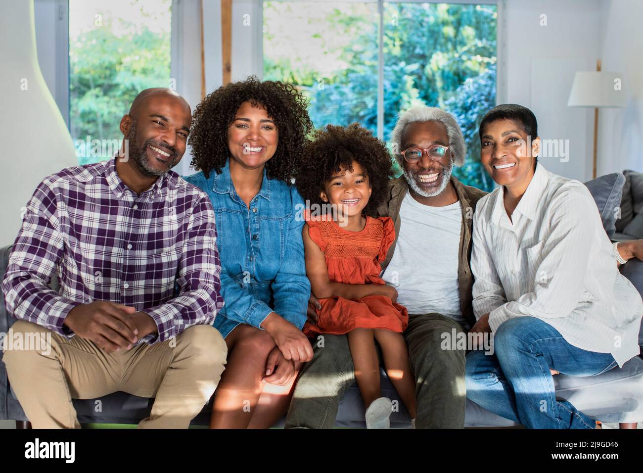 Happy multi-generation family sitting in living room Stock Photo