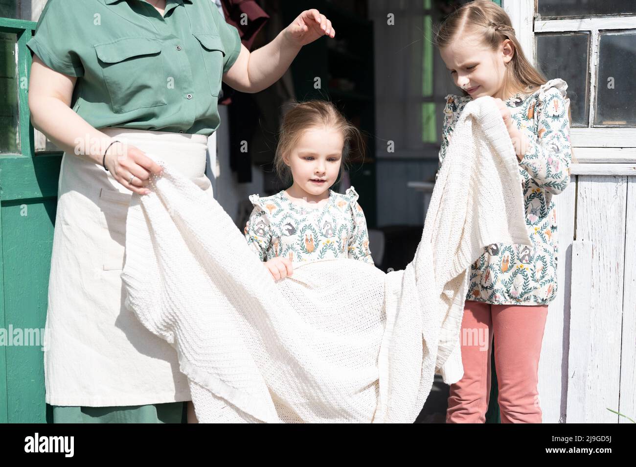Down Moms candid happy family mother with little kids daughters helper girls have fun in  suburb countryside life on sunny laundry day. candid mom and children doing  ch Stock Photo - Alamy