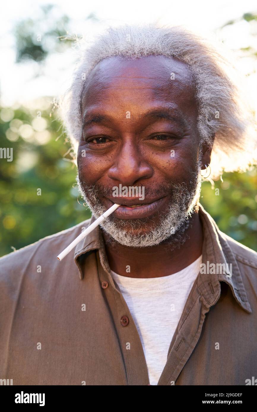 Close-up of a senior man holding cigarette in his mouth Stock Photo