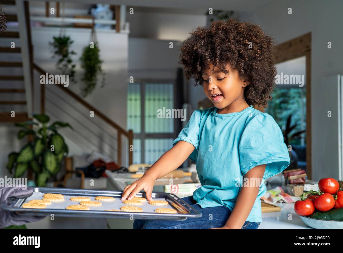 Mother's hand showing her daughter baked cookies in kitchen Stock Photo