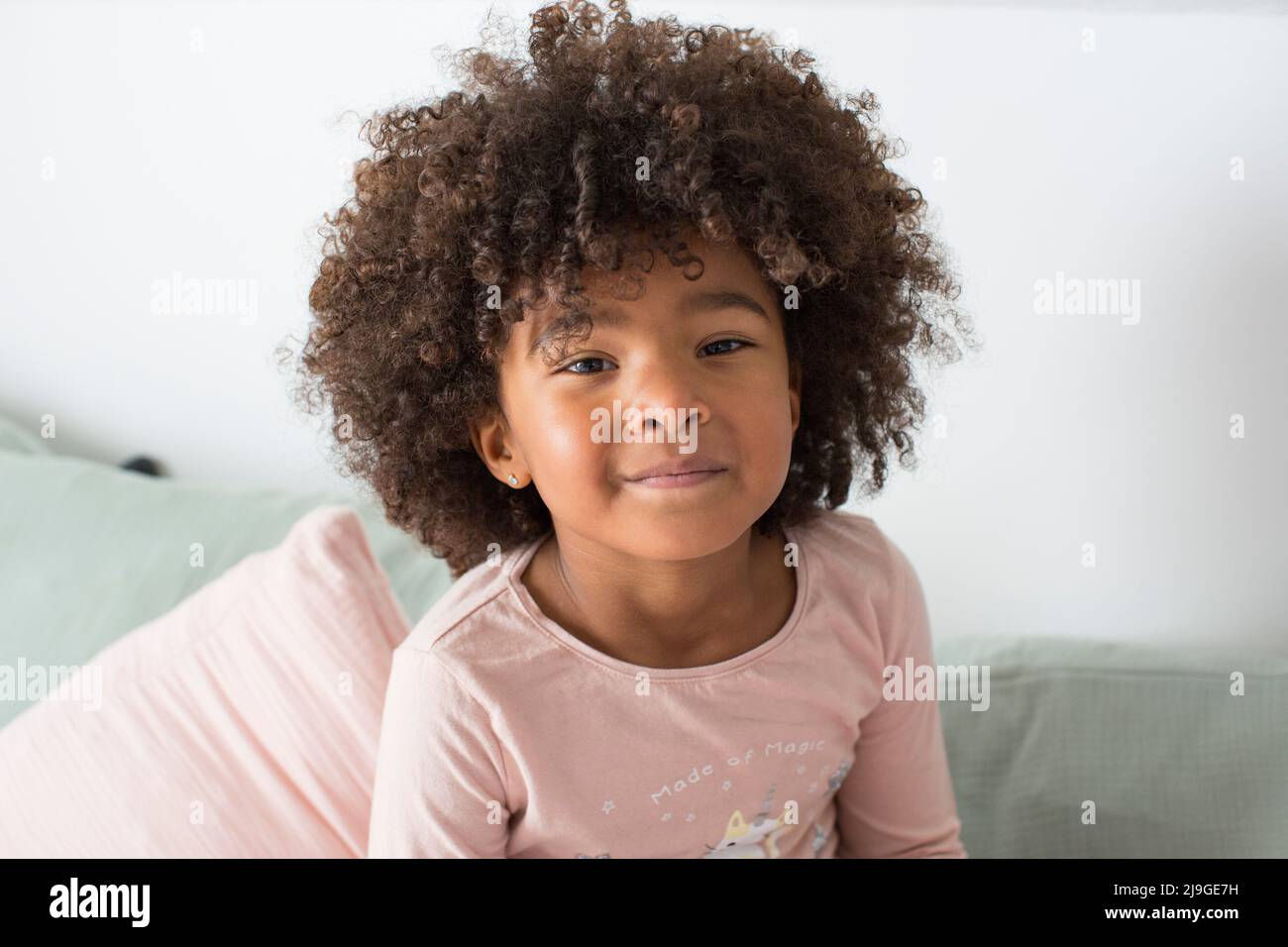 Portrait of a girl sitting on sofa Stock Photo - Alamy