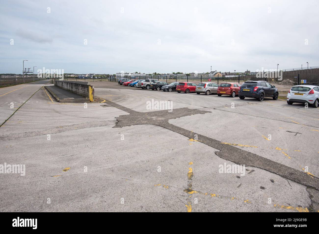 Cars (presumably rail travellers) parked close to Stranraer Harbour Railway Station & adjacent to disused lorry parking and former ferry port facility. Stock Photo