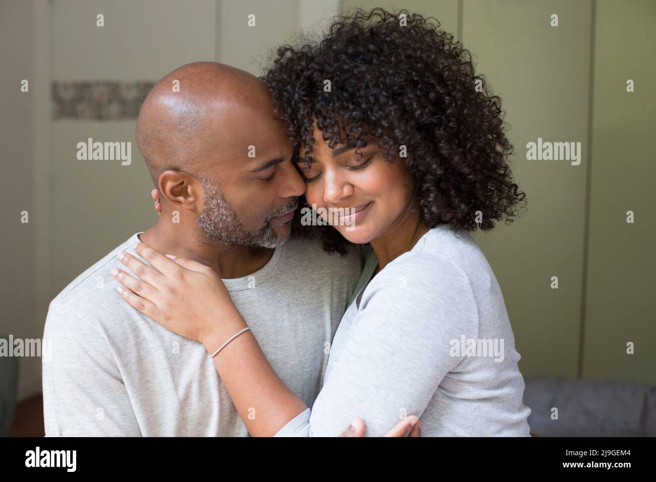 Couple romancing while sitting in bedroom Stock Photo