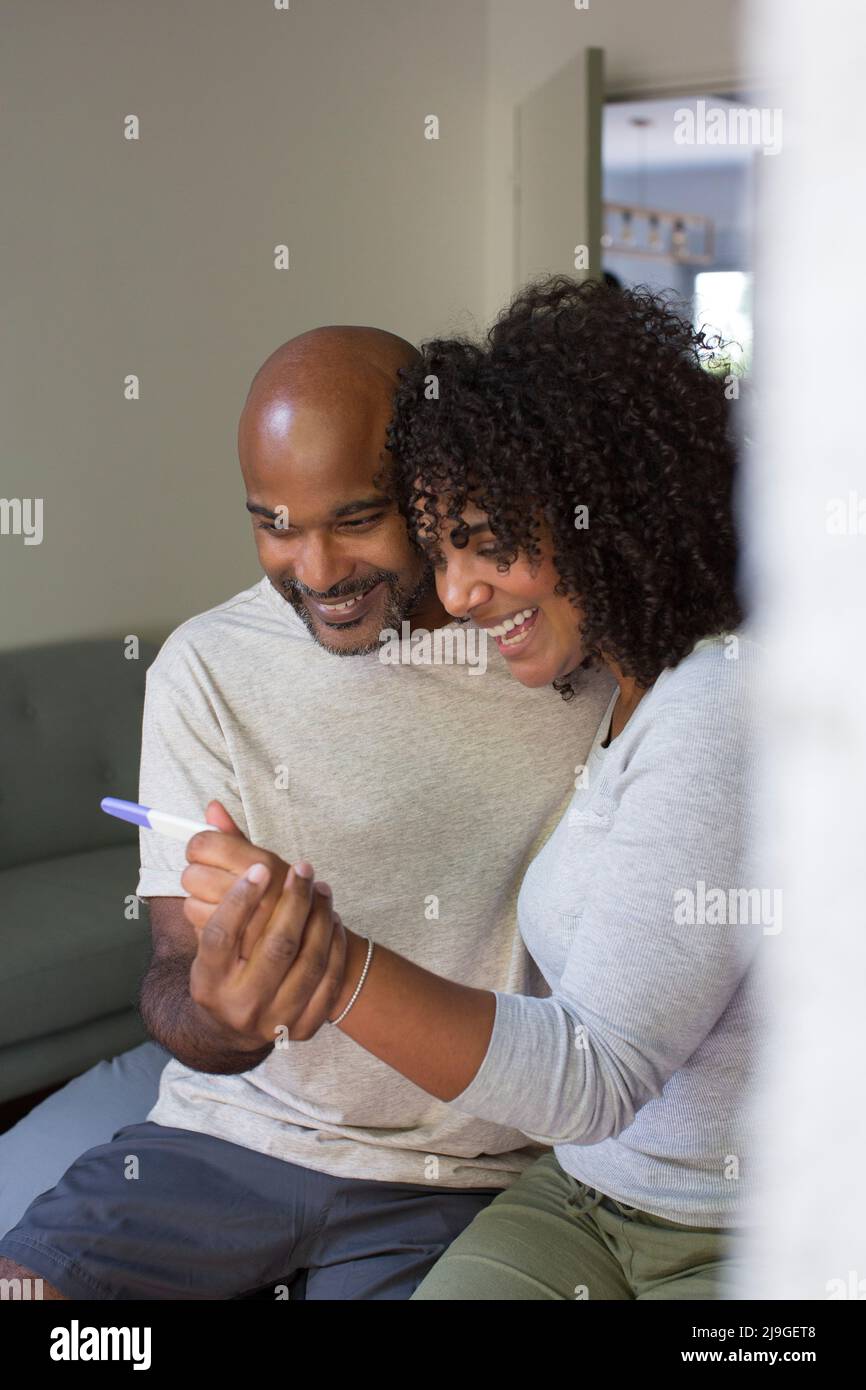 Happy couple holding pregnancy test kit Stock Photo - Alamy