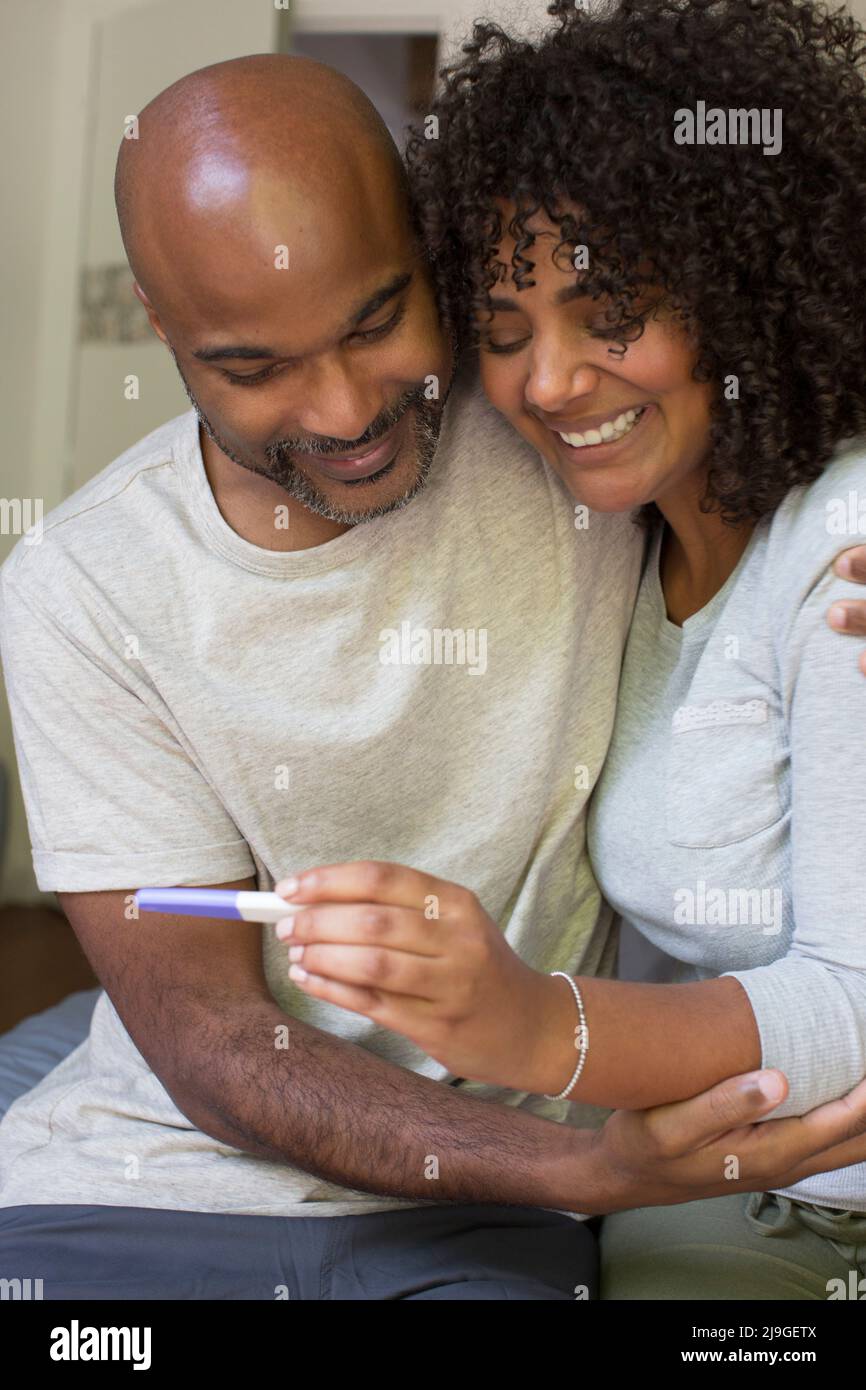 Happy couple holding pregnancy test kit Stock Photo - Alamy