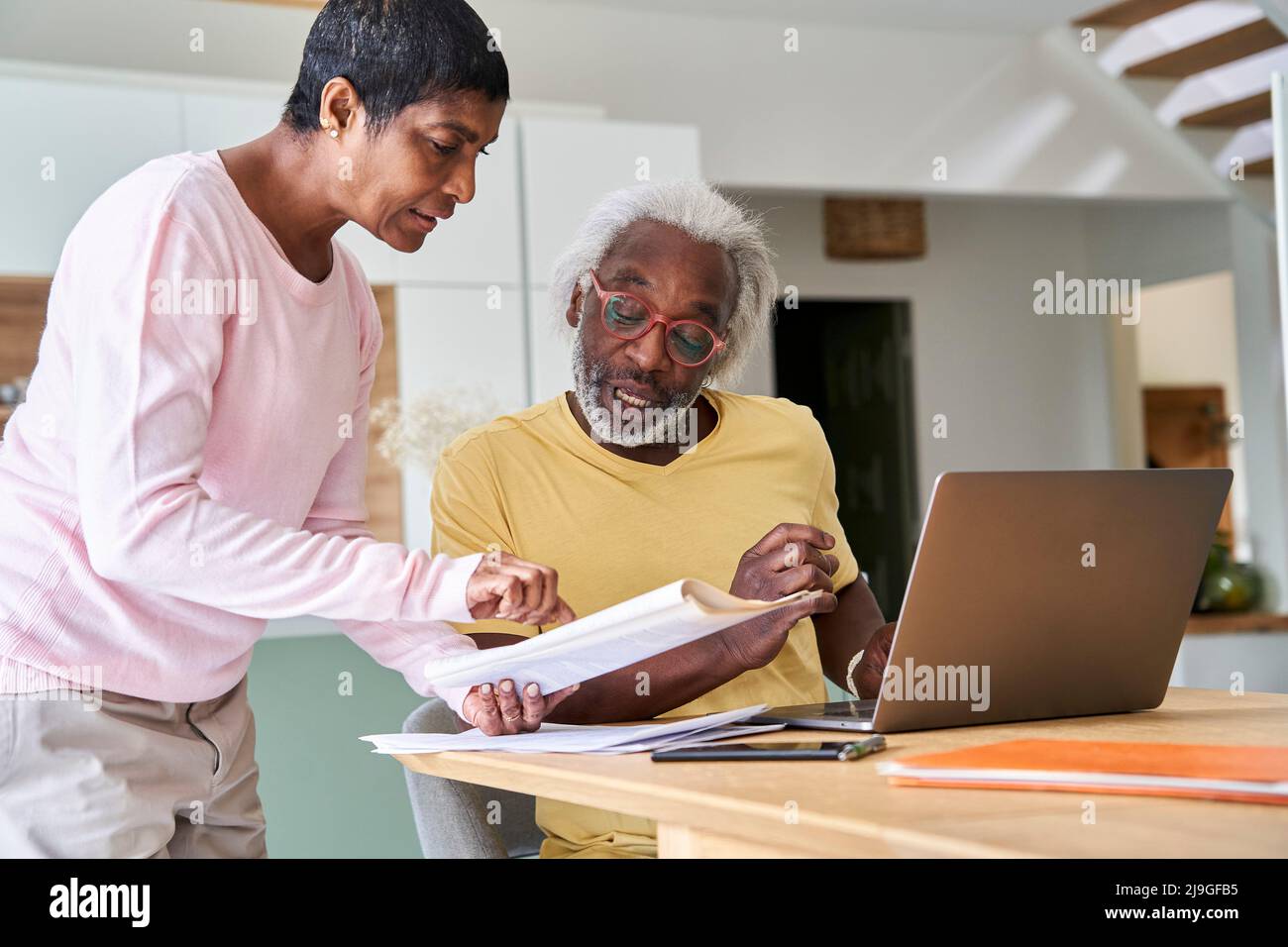 Couple using laptop in kitchen Stock Photo