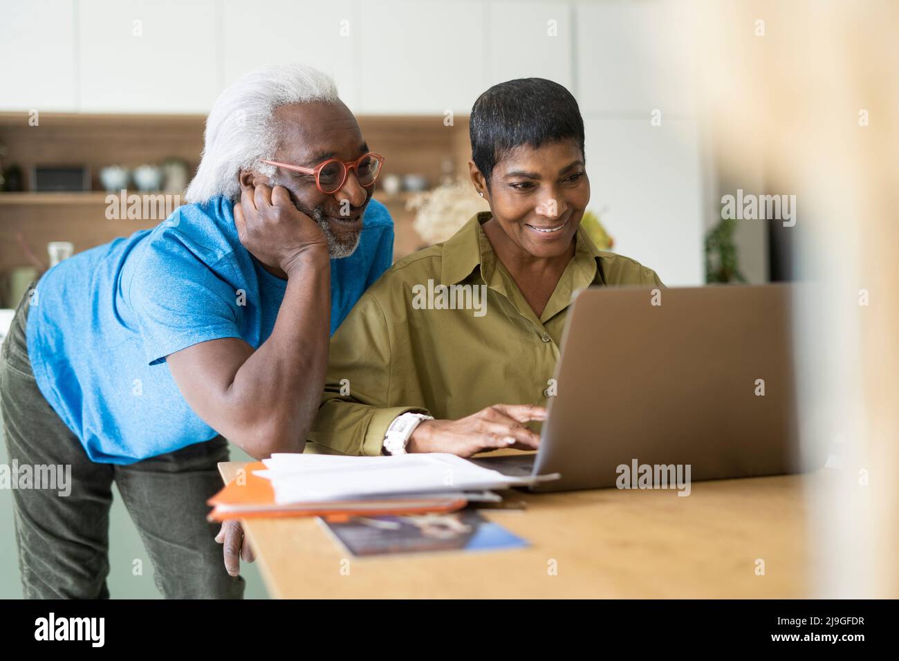 Couple using laptop in kitchen Stock Photo