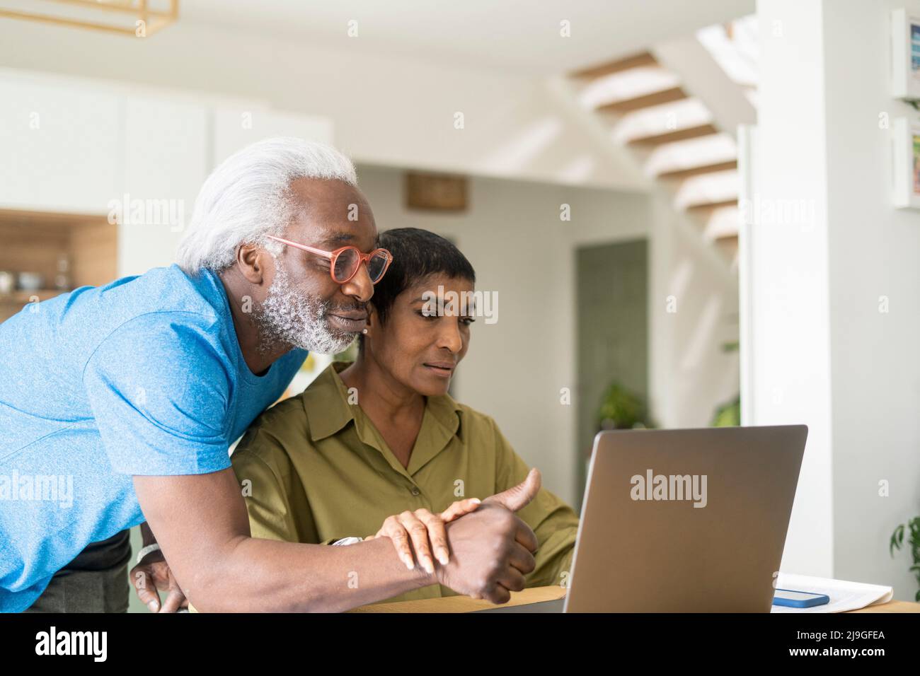 Couple using laptop in kitchen Stock Photo