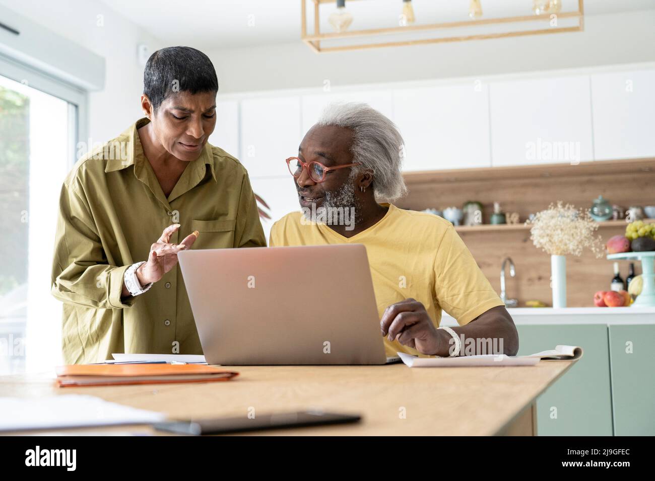 Couple using laptop in kitchen Stock Photo