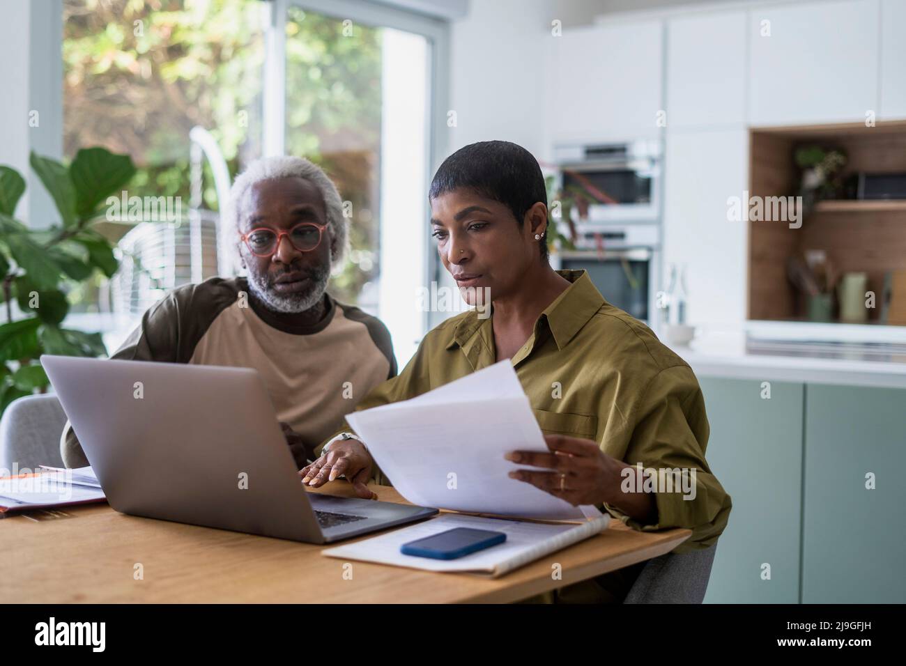 Couple checking documents in kitchen Stock Photo