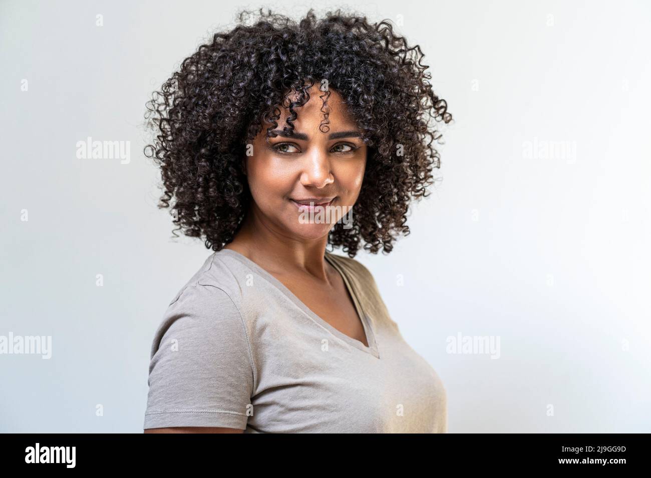 Woman standing against white wall Stock Photo