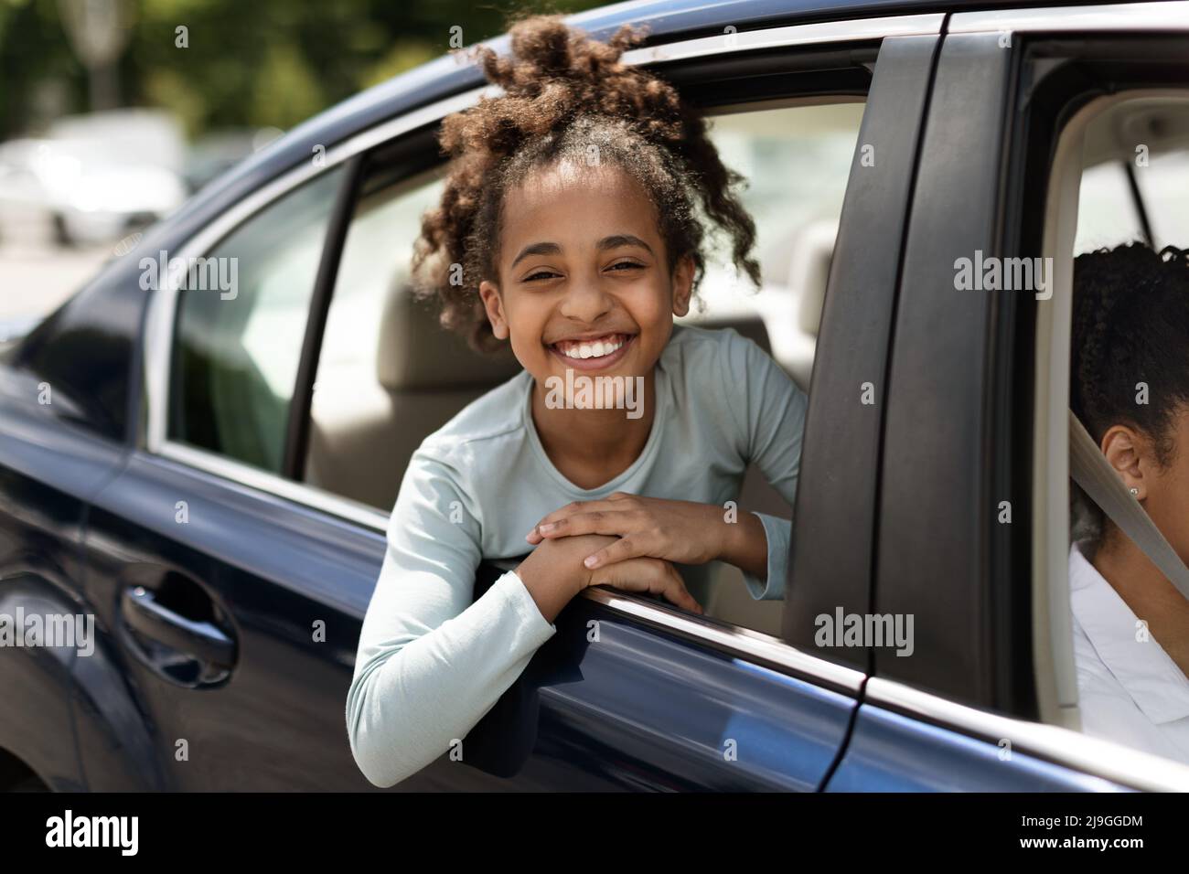 Happy Black Kid Girl Looking Out Of Car Window Stock Photo