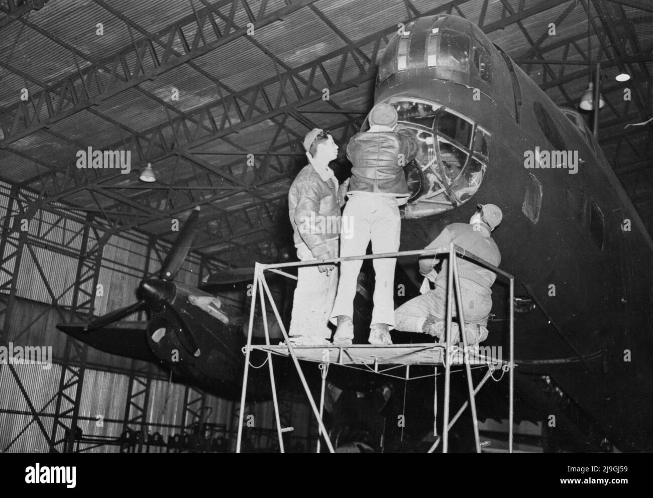 Vintage photo circa 1943 of American ground crew working on a British Royal Air Force Handley Page Halifax bomber during World War Two as part the cooperation between British and U.S. forces in Great Britain Stock Photo