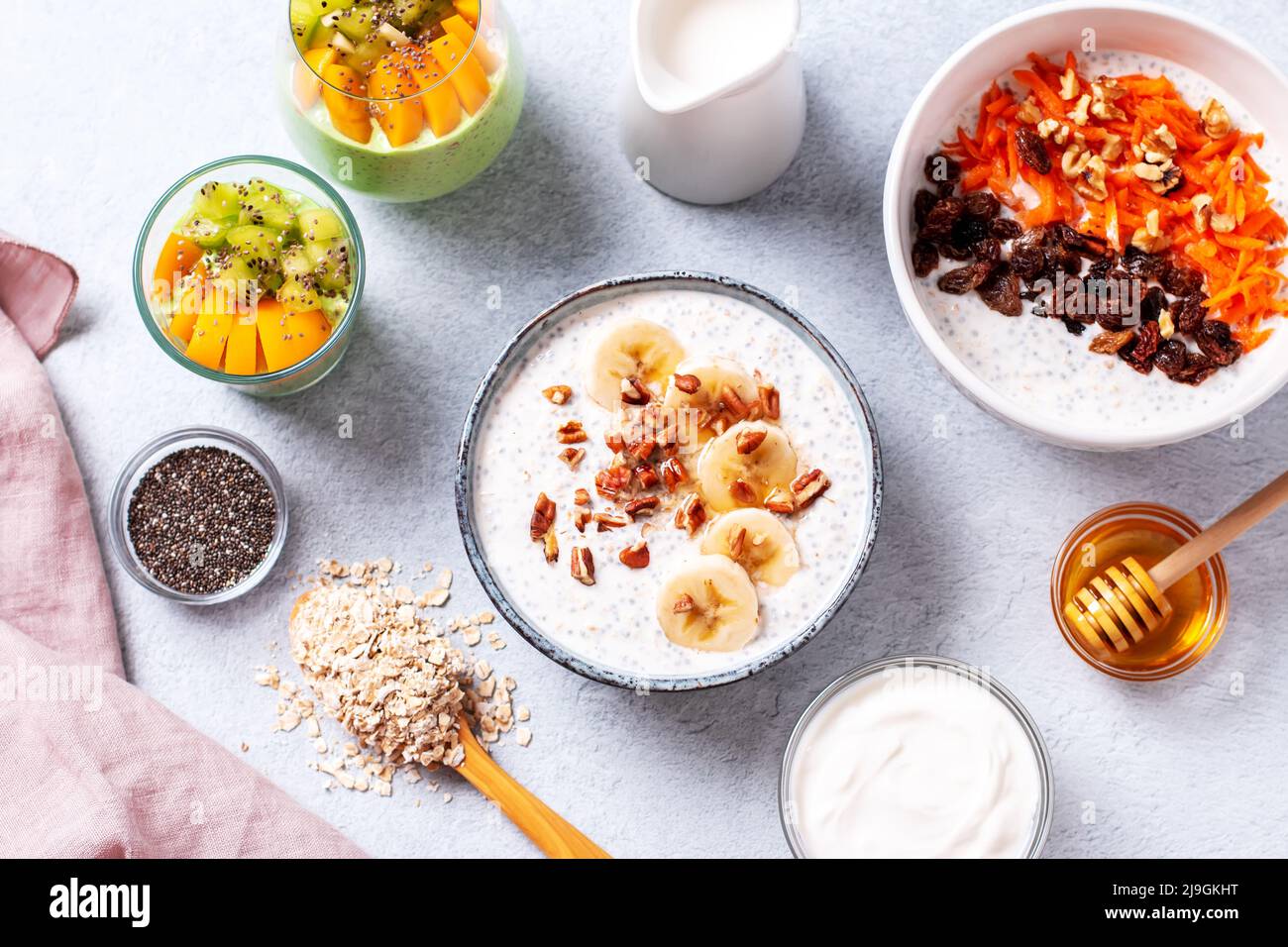 Ready table with high protein healthy breakfast with variety of overnight oats with nuts and fruits, top view Stock Photo
